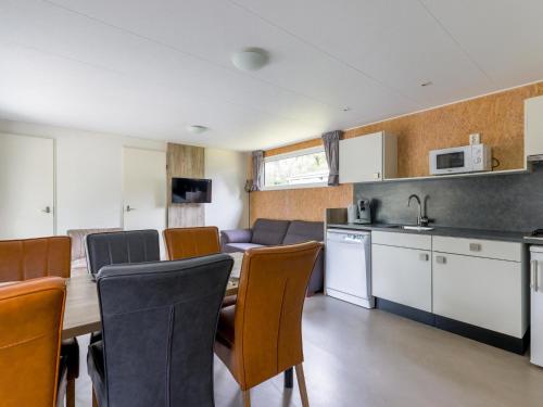 a kitchen and dining room with a table and chairs at Woodchalet in Vessem
