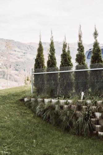 a fence in a field with trees behind it at Lebe`schlitters - Das Ferienapartmenthaus im Zillertal in Schlitters