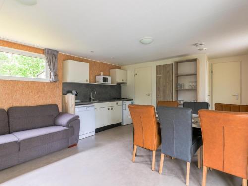 a kitchen and living room with a couch and a table at Woodchalet in Vessem