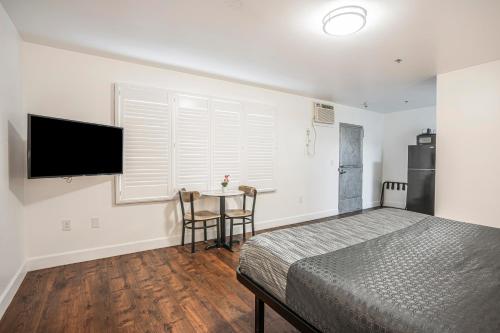 a bedroom with a bed and a table with chairs at The Greens Hotel on Del Paso in Sacramento