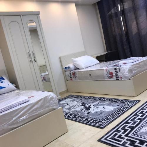 a small room with two beds and a mirror at فندق رويال هوم in Mansoura