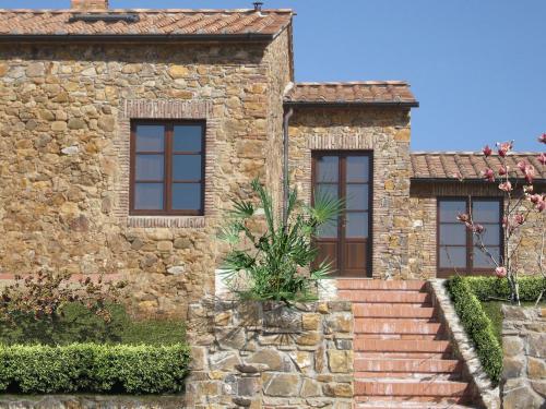 a stone house with a staircase in front of it at Antico Borgo Casalappi in Campiglia Marittima