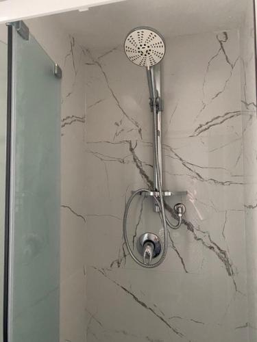 a shower in a bathroom with a marble wall at Casa ELLI in Rimini