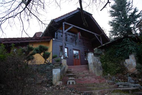 a house with a red door and stairs in front at Mohás Vendégház Kőszeg Mohás út 107 in Kőszeg
