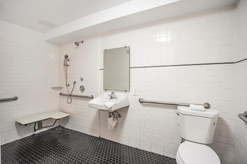 a bathroom with a toilet and a sink at The Greens Hotel on Del Paso in Sacramento