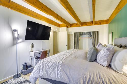 a bedroom with a bed and a flat screen tv at Cozy and Chic Lake Arrowhead Cabin with Deck! in Lake Arrowhead