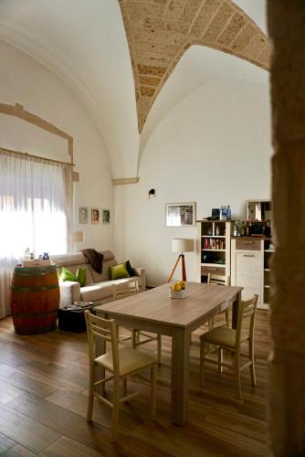 a living room with a wooden table and chairs at La Maison de Nicole 2 in Carmiano