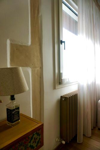 a lamp on a table next to a window with a radiator at La Maison de Nicole 2 in Carmiano
