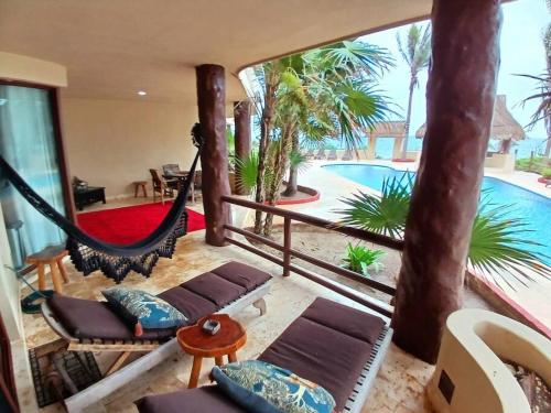 a room with a hammock and a swimming pool at Villa 301, Ground floor, Oceanfront! in Mahahual
