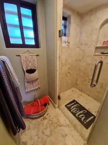 a bathroom with a shower with a basket and a window at Villa 301, Ground floor, Oceanfront! in Mahahual