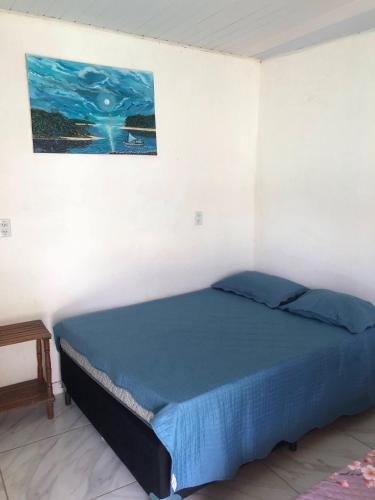 un letto in una stanza con un dipinto sul muro di Pousada Samreny a Maracanã