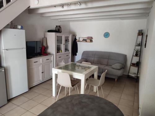 une cuisine et un salon avec une table et un canapé dans l'établissement Maison L'Olivier ,6 couchages St Cyprien plage 3 étoiles, à Saint Cyprien Plage