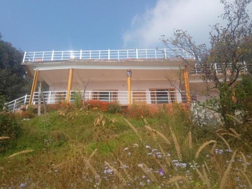 a house on top of a hill with flowers at Kumaon Lake's Home stay in Nainital