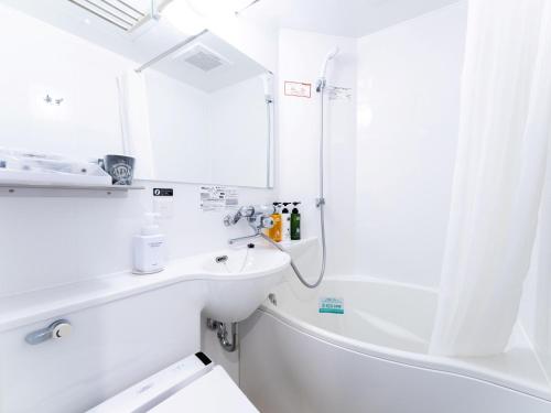 a white bathroom with a sink and a shower at APA Hotel Nagoya Ekimae Kita in Nagoya