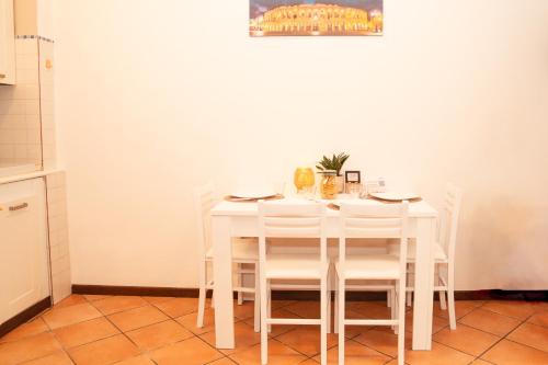 un tavolo bianco con sedie bianche in cucina di Residenza Longhena a Verona