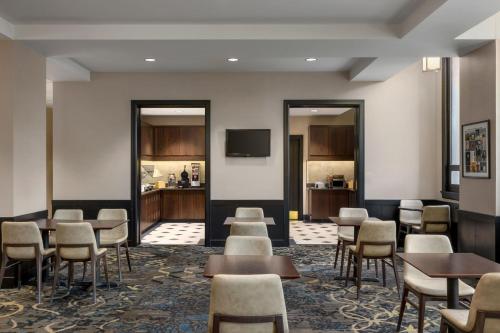 Una sala de espera con mesas y sillas y un televisor. en Residence Inn by Marriott Omaha Downtown Old Market Area, en Omaha