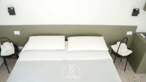 a bedroom with a bed with two white pillows at Agathè Luxury Bed and Breakfast in Marina di Schiavonea