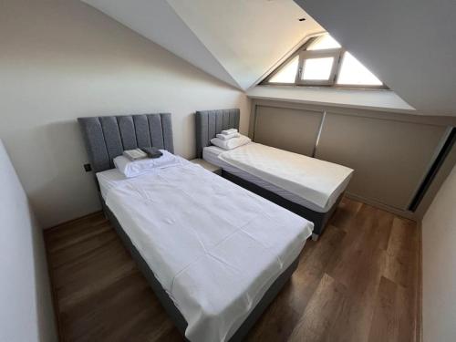 two beds in a small room with a window at Kemer Green Park Villa in Kemer