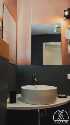 a bathroom with a white sink and a mirror at Agathè Luxury Bed and Breakfast in Marina di Schiavonea