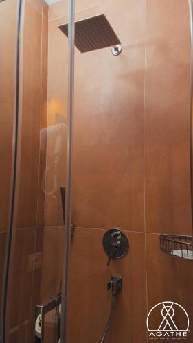 a shower with a glass door and a shower head at Agathè Luxury Bed and Breakfast in Marina di Schiavonea