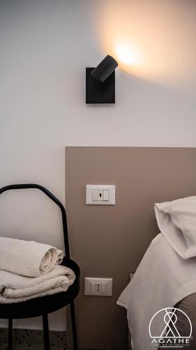 a room with a bed and a lamp and a chair at Agathè Luxury Bed and Breakfast in Marina di Schiavonea