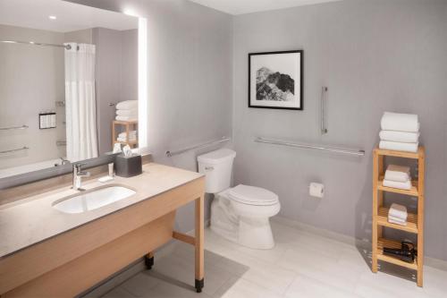 a bathroom with a sink and a toilet and a mirror at Hyatt Place Reno in Reno