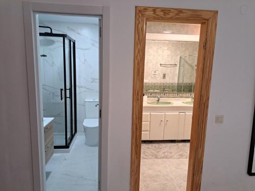 a bathroom with a toilet and a mirror at Spacious Apartment in Villa Noelia Benalmadena with Private Pool, Garden & Parking in Benalmádena
