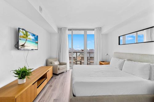 a hotel room with a bed and a tv at Top Luxury Apartment with Pool & Gym in Hallandale Beach