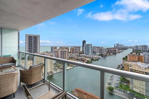 a balcony with chairs and a view of the water at Top Luxury Apartment with Pool & Gym in Hallandale Beach