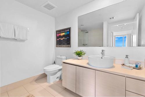 Un baño blanco con lavabo e inodoro. en Top Luxury Apartment with Pool & Gym, en Hallandale Beach