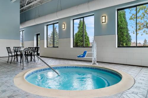 a hot tub in a room with a table and chairs at HomeTowne Studios by Red Roof Flint in Flint