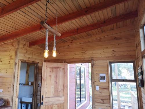 a room with a wooden ceiling and a door at Rukawe Quillon in Quillón