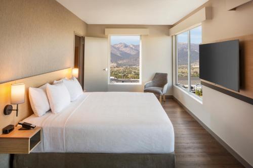 a hotel room with a bed and a large window at Hyatt Place Reno in Reno