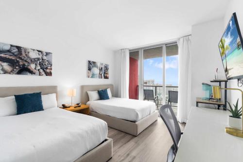 a hotel room with two beds and a balcony at Modern New Studio Balcony & Pool in Hallandale Beach