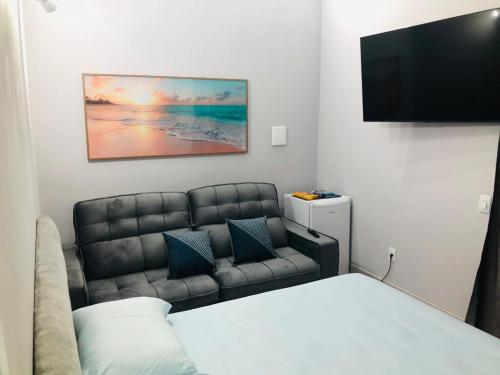 a room with a bed and a couch and a flat screen tv at Valentina 24 HORAS in Florianópolis