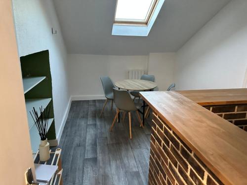 une pièce avec une table, des chaises et une fenêtre dans l'établissement Le MONTLUSPOT, à Montluçon