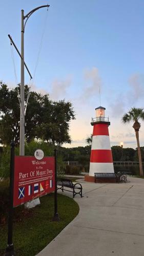 a red and white lighthouse with a sign in front of it at Doras Dream, 4 Bedrooms, Sleeps 12, Downtown in Mount Dora