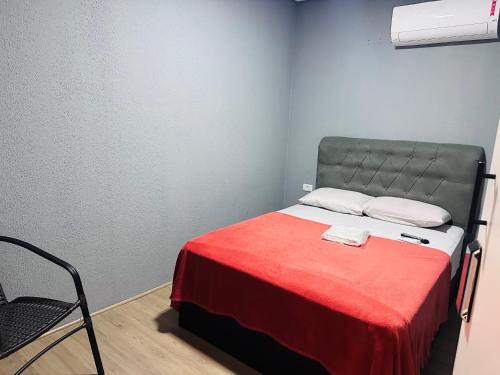 a small bedroom with a bed with a red blanket at On Park Hotel e Traslado in Guarulhos