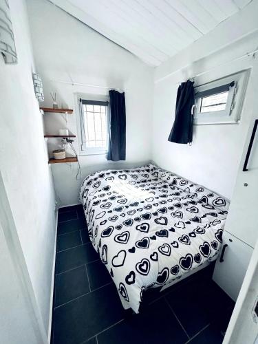 une chambre avec un lit avec une couette noire et blanche dans l'établissement Mas provençal avec piscine - Coin de Paradis, à Puget-sur Argens