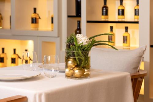 a vase with flowers and balls on a table with wine bottles at Hotel Arts Barcelona in Barcelona