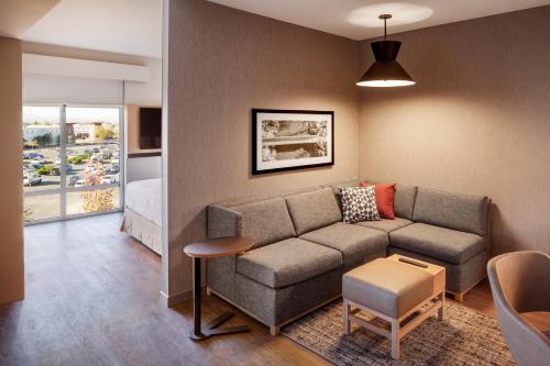 a living room with a couch and a bed at Hyatt Place Reno in Reno