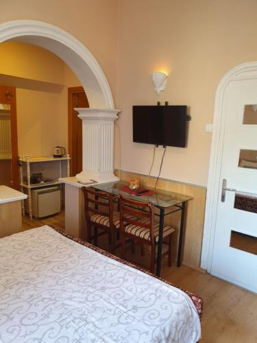 Un dormitorio con una cama, una mesa y un televisor. en Malgo, en Vrnjačka Banja