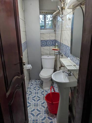 a bathroom with a white toilet and a sink at RÉSIDENCE 2K Studio Meublé-Chapelle Symbock-Gardien-WIFI-Location Véhicule in Yaoundé