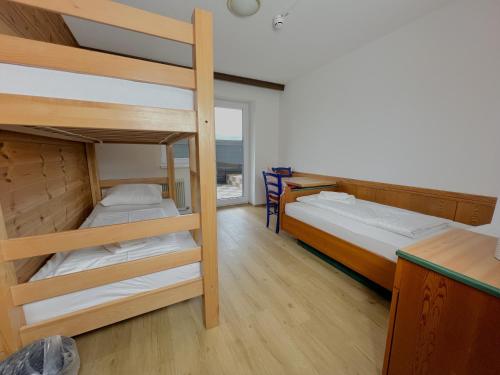 two bunk beds in a room with a window at Mountain Hotel & Hostel in Ramsau am Dachstein