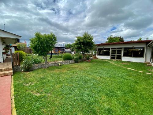 a yard of a house with a yard of green grass at Alojamiento RBOY Las Mariposas in Chillán