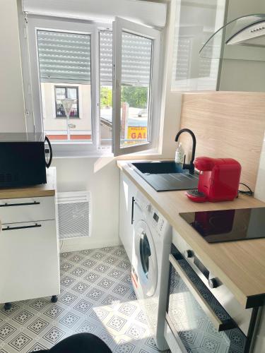 une petite cuisine avec une machine à laver et un évier dans l'établissement ChicCosy Studio 2mn RER proximité Paris Aéroport Cdg, à Villepinte