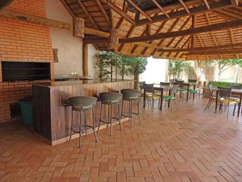 a bar with chairs and tables in a patio at Bravo City Rondonópolis in Rondonópolis