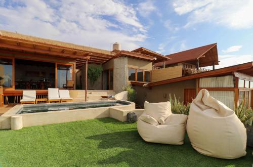 a house with two bean bags on the lawn at Casa Kahu by Wynwood House in Los Órganos