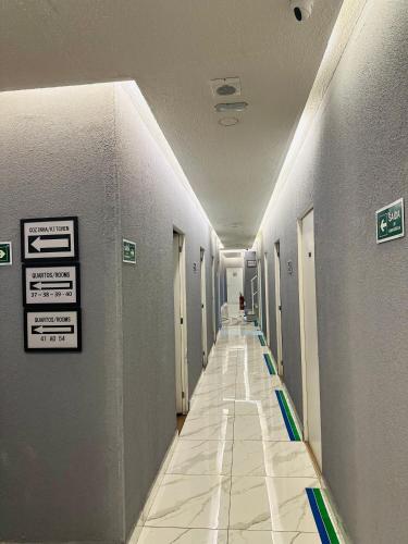 a hallway of a hospital with signs on the walls at On Park Hotel e Traslado in Guarulhos