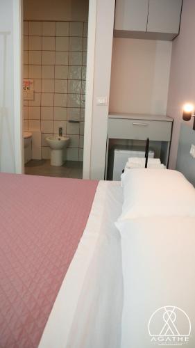a bedroom with a bed and a bathroom with a toilet at Agathè Luxury Bed and Breakfast in Marina di Schiavonea